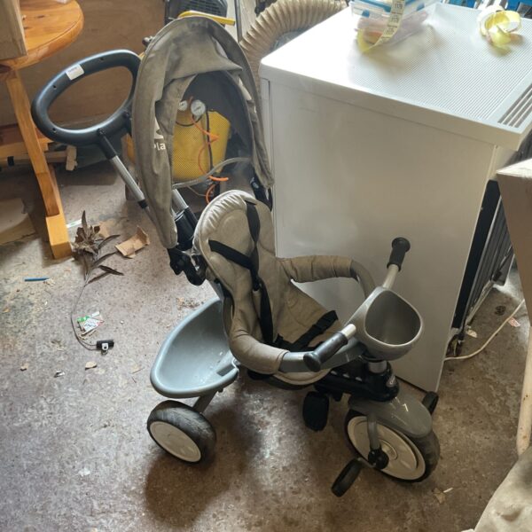 Used baby stroller with pedals for toddlers, showing wear.