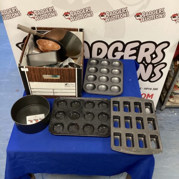 Mixed lot of baking trays and sieves on a table.