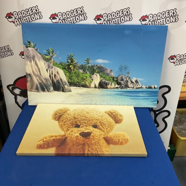 Two canvas prints, a beach scene and a teddy bear, for home decor.