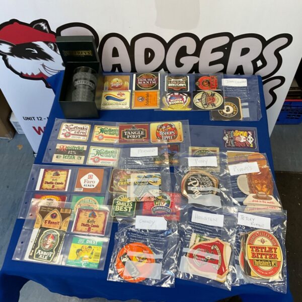 Vintage beer mats and labels collection, showcasing brewery advertising.