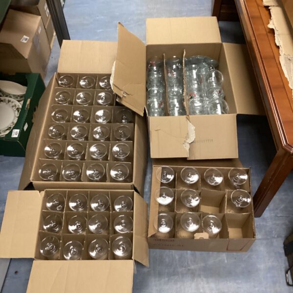 Four boxes of Birra Moretti pint and half-pint glasses stacked together.
