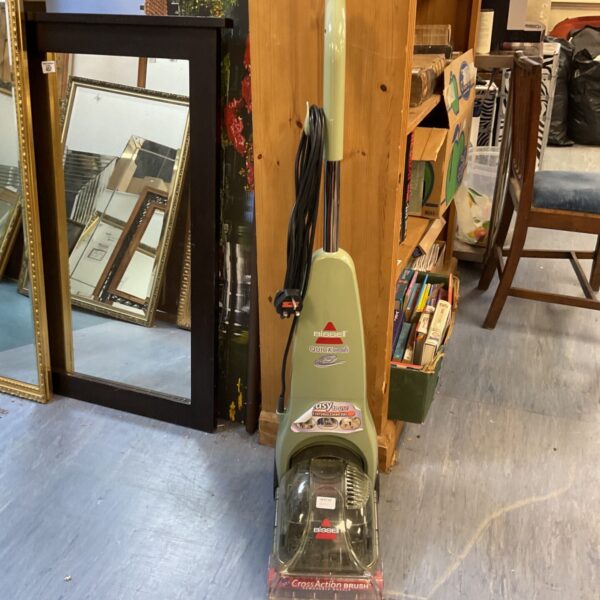Bissell QuickWash carpet cleaner with mirror and bookcase in background.