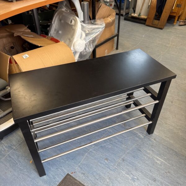 Black shoe rack with chrome bars for organized shoe storage.