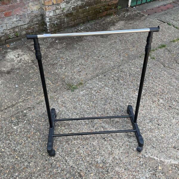 Black portable clothes rail with wheels for garment storage.