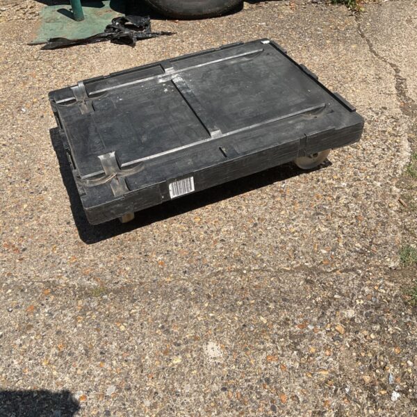 Heavy duty black plastic dolly for transporting crates and containers.