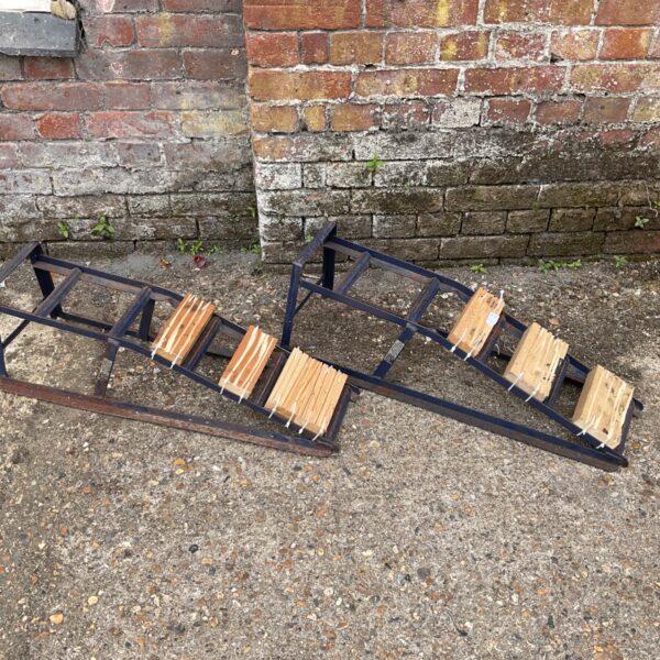 Blue steel car ramps for vehicle maintenance and repair.