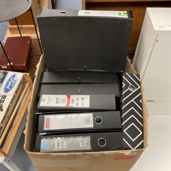 A box filled with black lever arch box files for document storage.