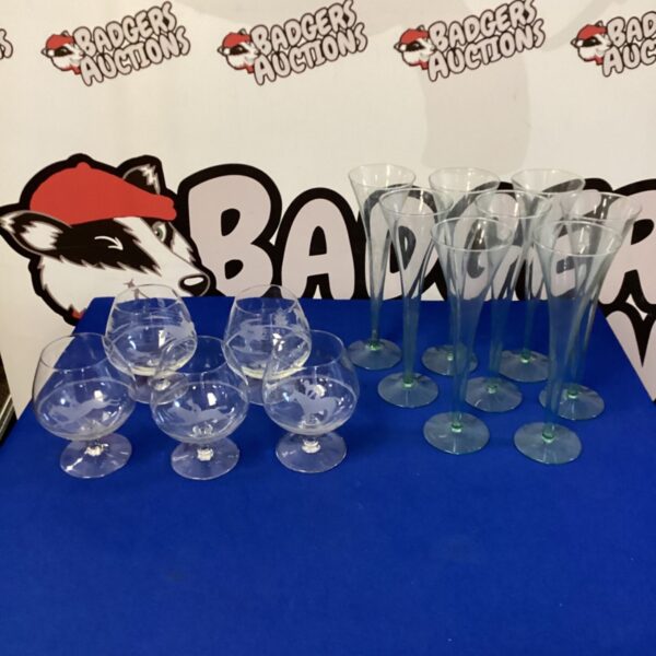 Mixed lot of vintage brandy glasses and champagne flutes on display.