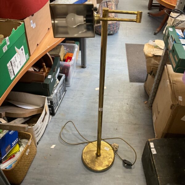 Vintage brass floor lamp awaiting restoration, classic mid-century design.