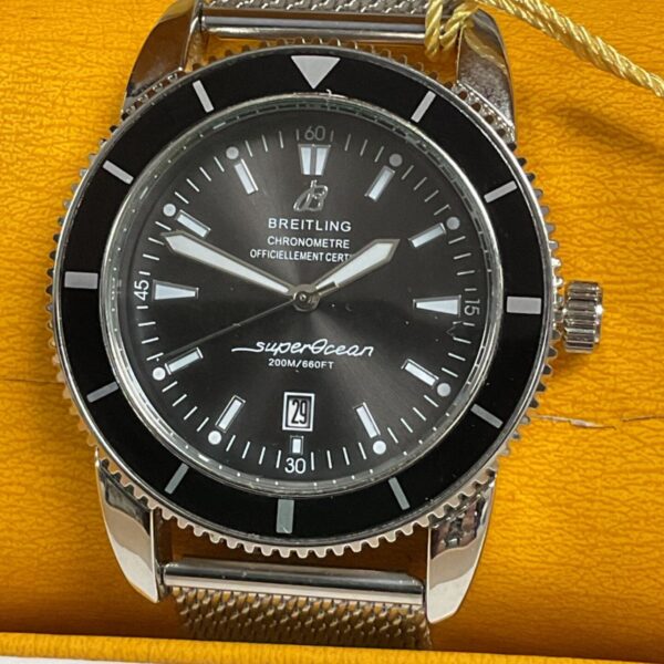 Close-up of Breitling SuperOcean watch with black dial and steel bracelet.