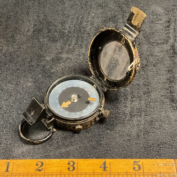 Vintage British Army compass by E Barker and Son, showing the dial.