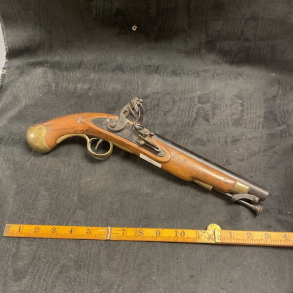 Antique British flintlock pistol with brass guard and wooden stock.