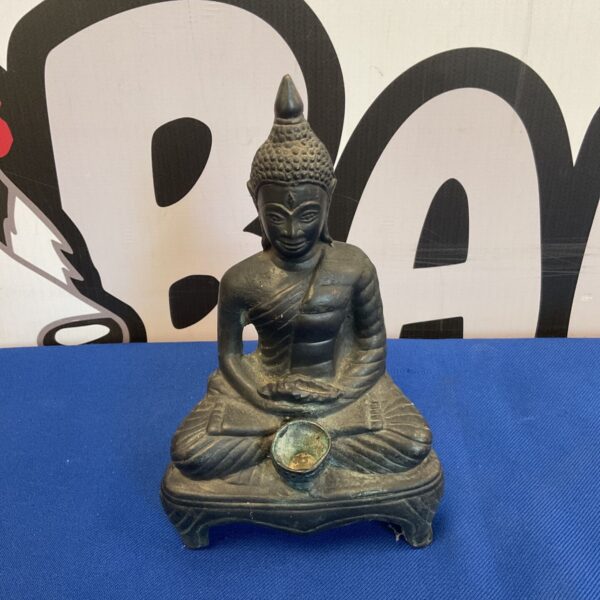 Bronze Buddha incense holder in meditative pose.