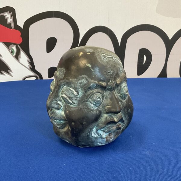Detailed bronzed Buddha head sculpture with many faces.