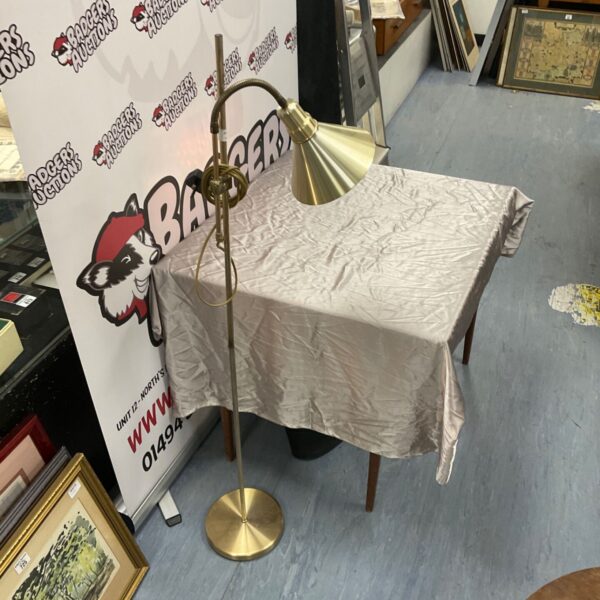 Vintage brushed brass floor lamp with a conical shade.