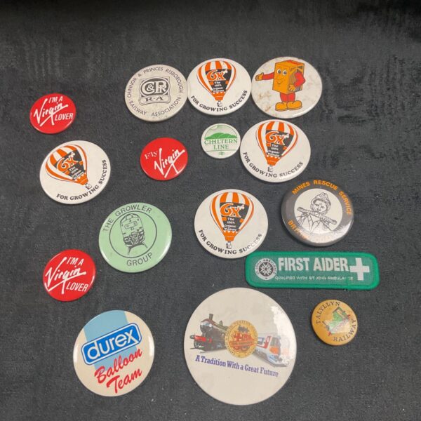 Collection of vintage button badges with steam train and balloon designs.