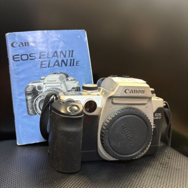 Canon EOS ELAN II film camera with manual, vintage photography.