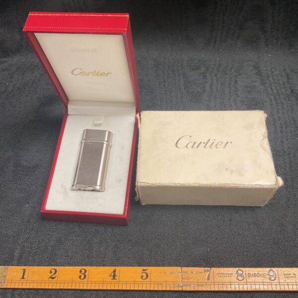 Vintage Cartier lighter in red presentation box, collectible item.