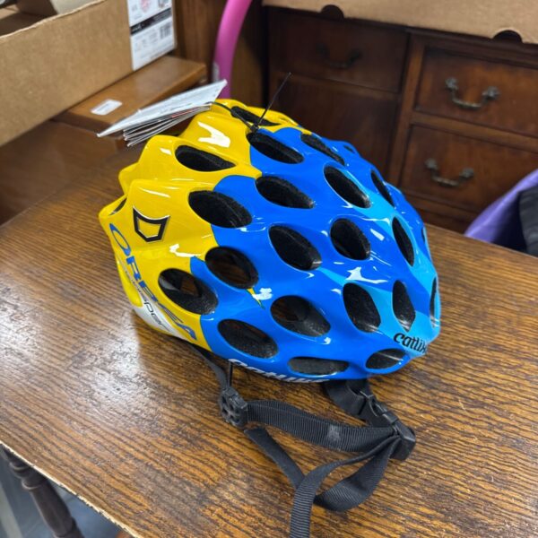 Yellow and blue Catlike Orbea Whisper cycling helmet on wooden surface.