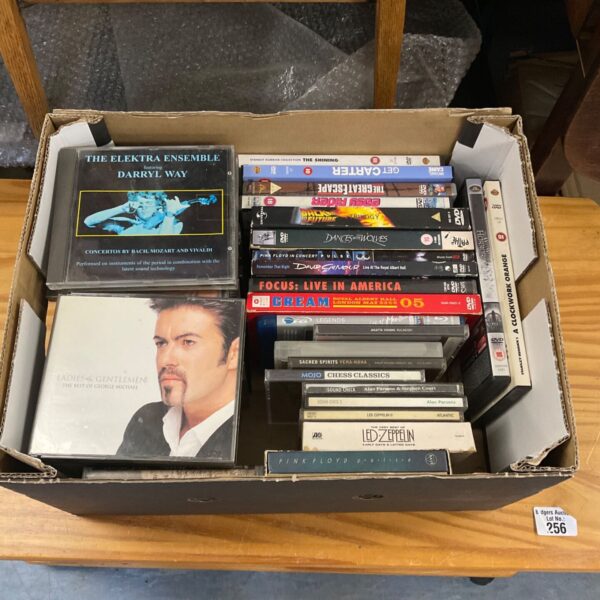 Box of assorted CDs and DVDs for home entertainment.