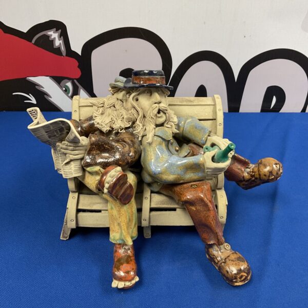 Vintage ceramic sculpture of two drunk men on a bench.