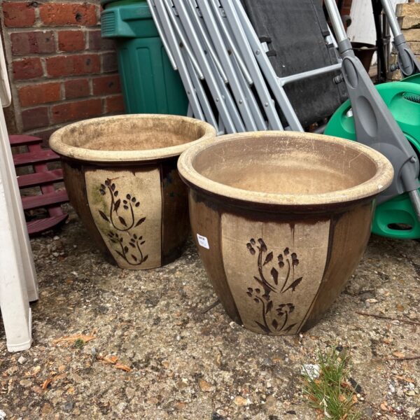 Pair of terracotta ceramic garden pots with floral design.