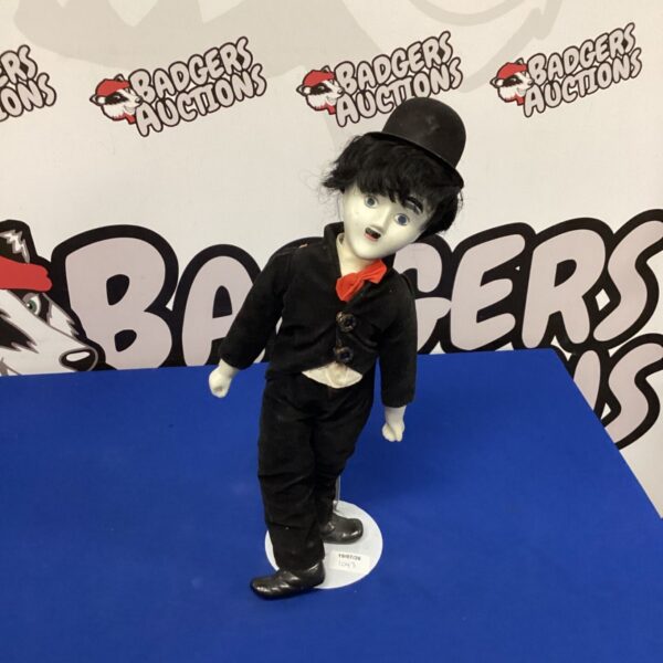 Vintage porcelain Charlie Chaplin doll in classic Tramp attire.