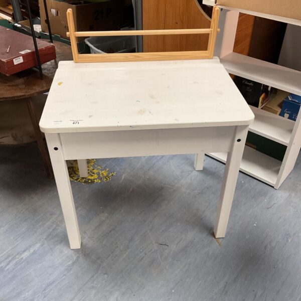 White children’s desk with signs of wear, ideal for a playroom.