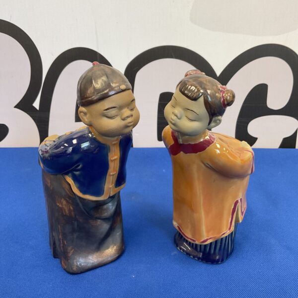 Vintage Chinese Mudman figurines of a kissing boy and girl.