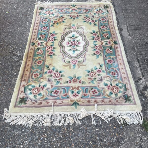 Beige Chinese wool rug with floral medallion pattern.