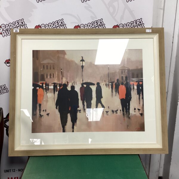 Large framed cityscape art print with silhouetted figures walking.