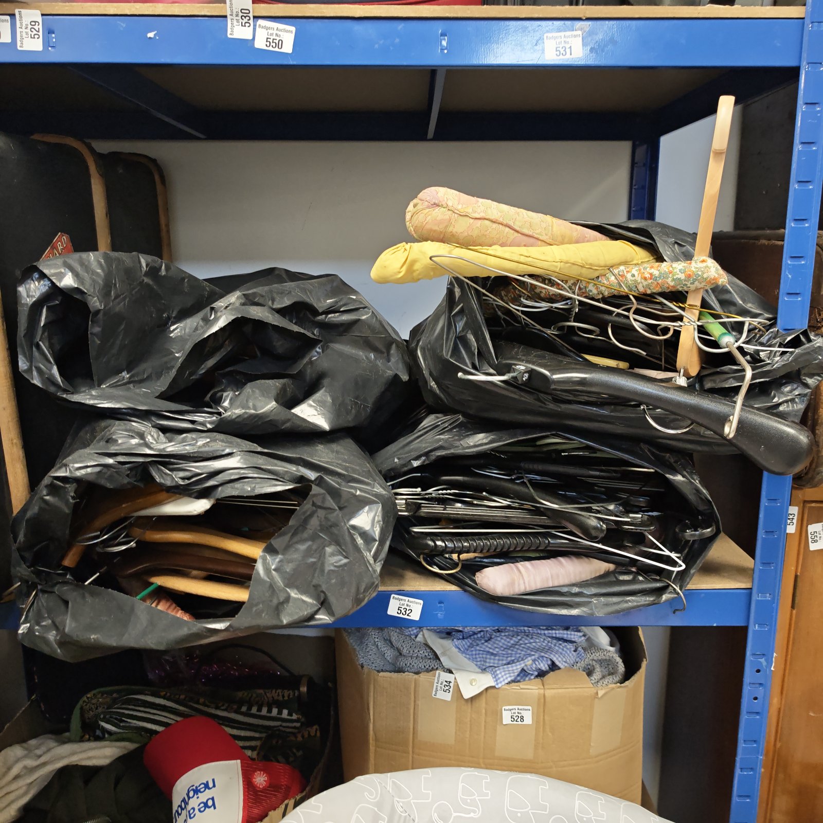 Lot of four bags filled with plastic clothes hangers for storage.
