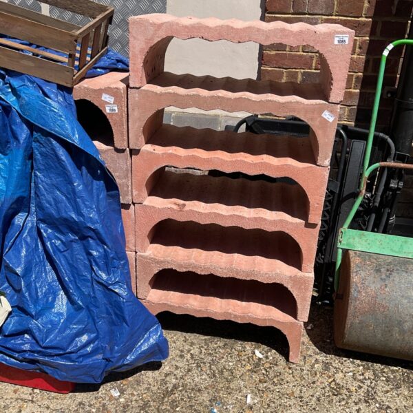 Six weathered concrete wine storage units for garden display.