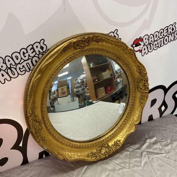 Ornate gilt framed French style convex mirror for wall decoration.