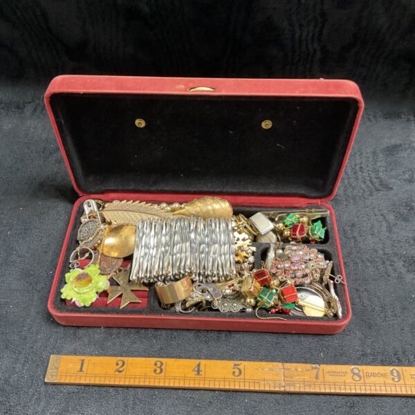 Vintage costume jewellery box filled with brooches, necklaces and earrings.
