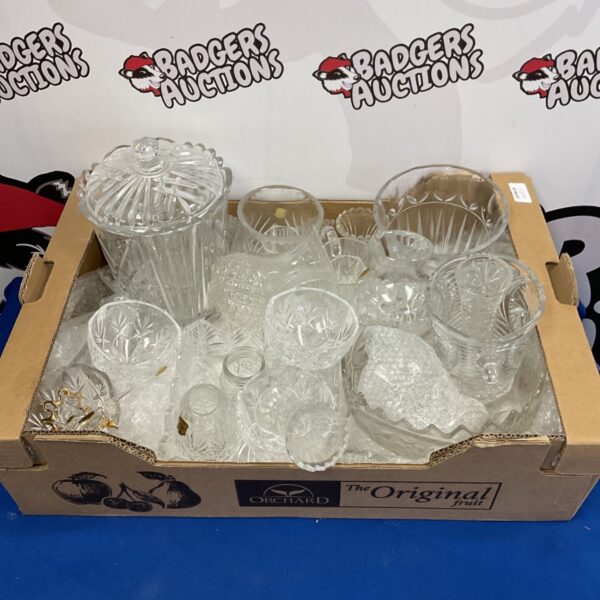 Collection of cut glass vases and bowls on a patterned surface.