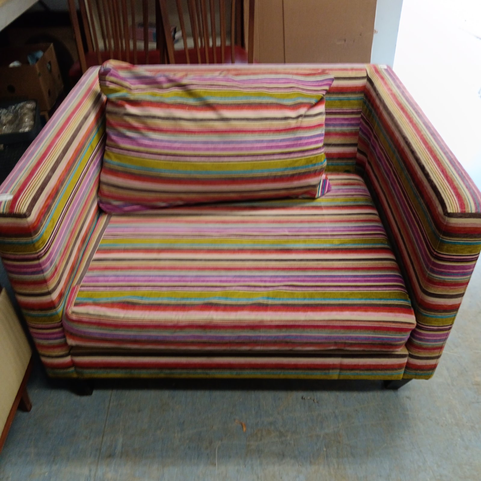 Vibrant Designers Guild cuddle chair with colourful stripes.