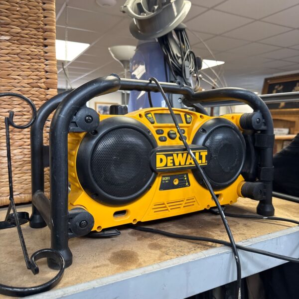 Yellow and black Dewalt DC011 site radio on a workbench.