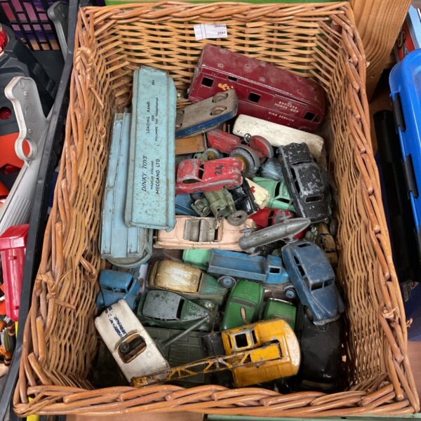 Vintage Dinky Toys diecast cars and trucks in a basket.