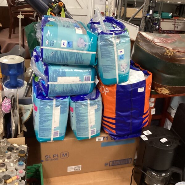 Lot of disposable Tena bed pads for incontinence protection.