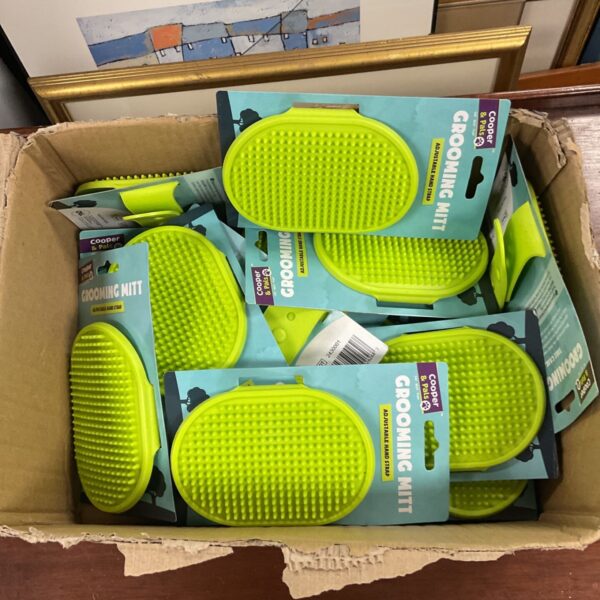 Box of new dog grooming mitts for pet hair removal.