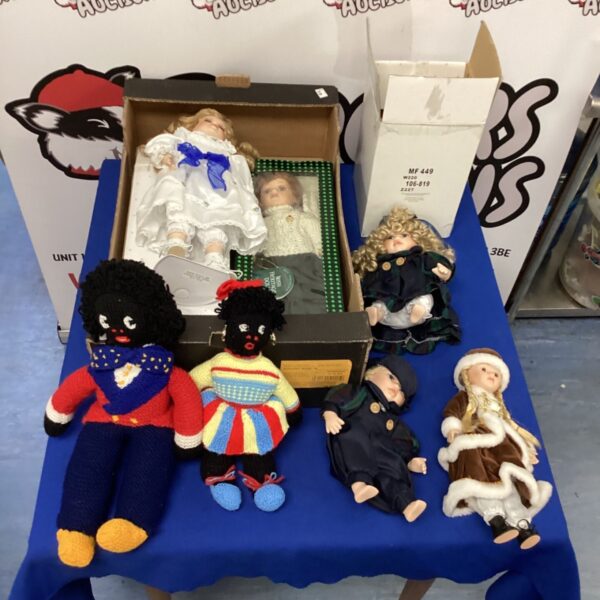Tray of vintage dolls including porcelain and golly dolls.