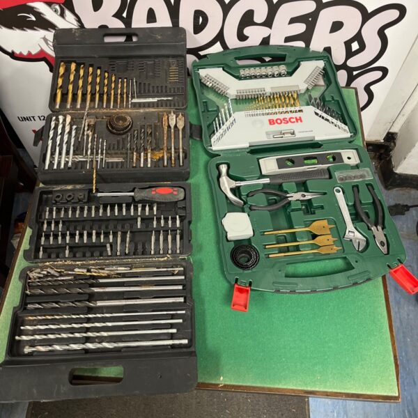 Assorted drill bit set and tools in plastic storage boxes.