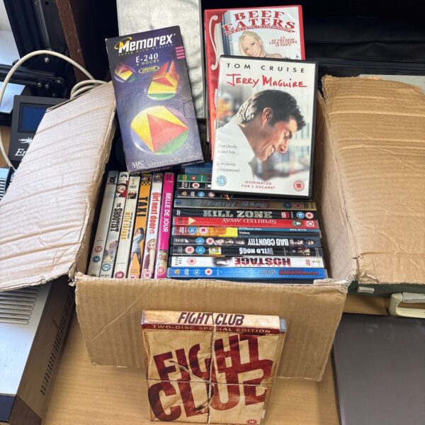 Mixed lot of DVDs and VHS tapes for vintage movie collection.