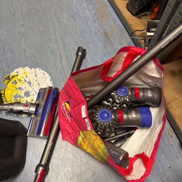 Assorted Dyson hoover parts including motors and brush heads.