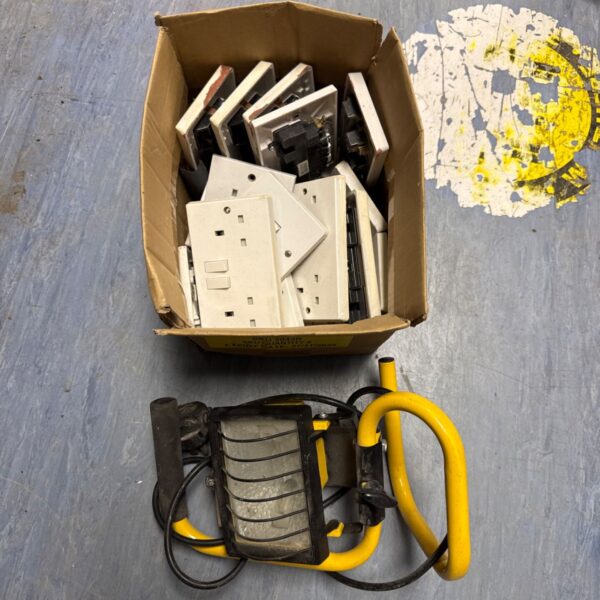 Box of assorted electrical sockets and a 240v site light for DIY projects.