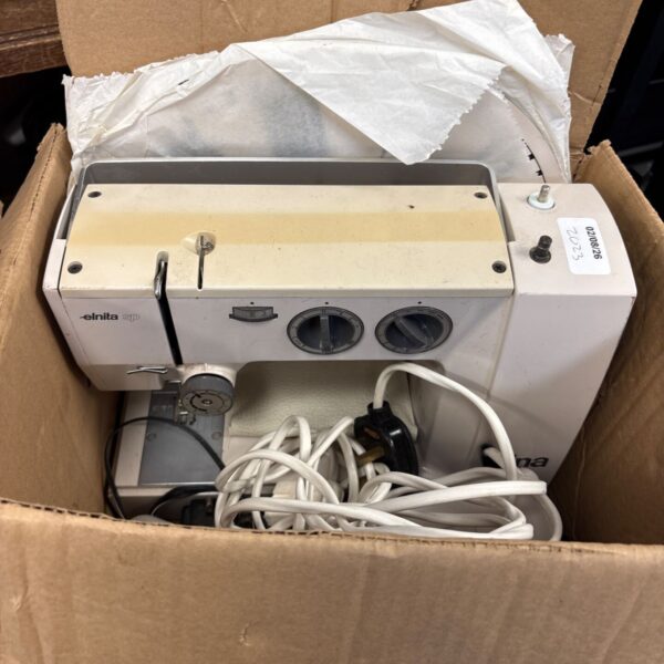 Vintage Elnita SP sewing machine with accessories for collectors.