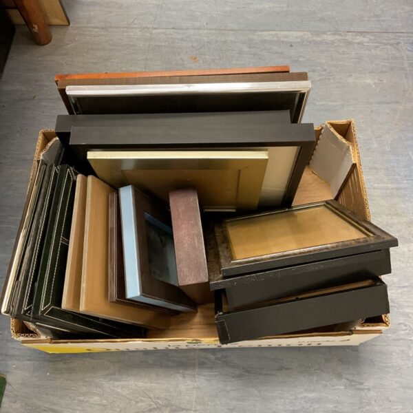 Assorted empty picture frames in a cardboard box, ready for use.