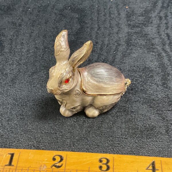 Close-up of vintage enamelled rabbit trinket box with red eyes.