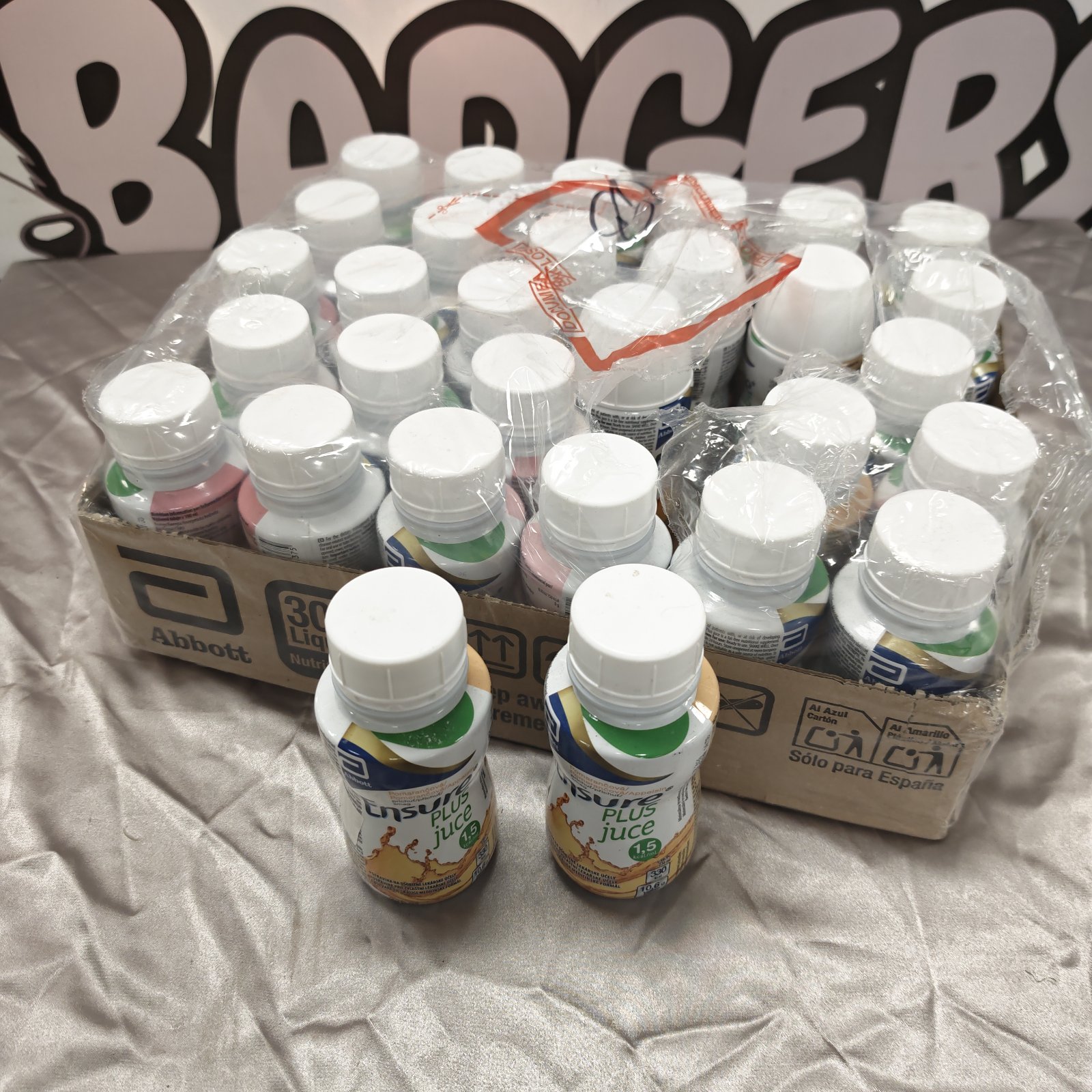 Box of Ensure Plus juice bottles, nutritional supplement drink.